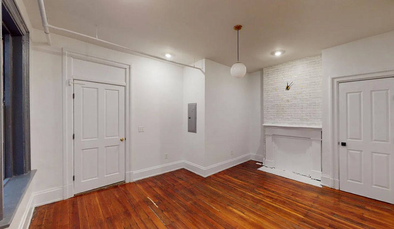 Living room with original hardwood floors and a white brick fireplace