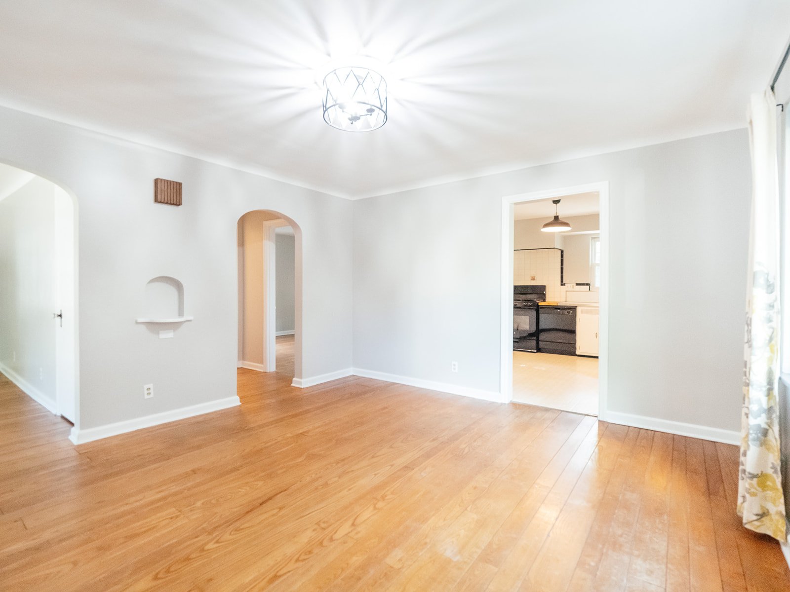 Bright dining room with hardwood floors and arched doorways