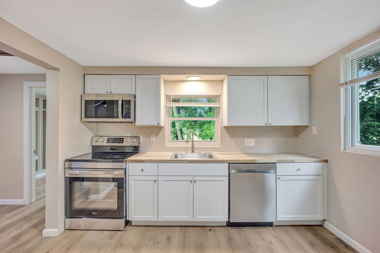 Kitchen with white cabinets, butcher-block counters, and stainless steel appliances