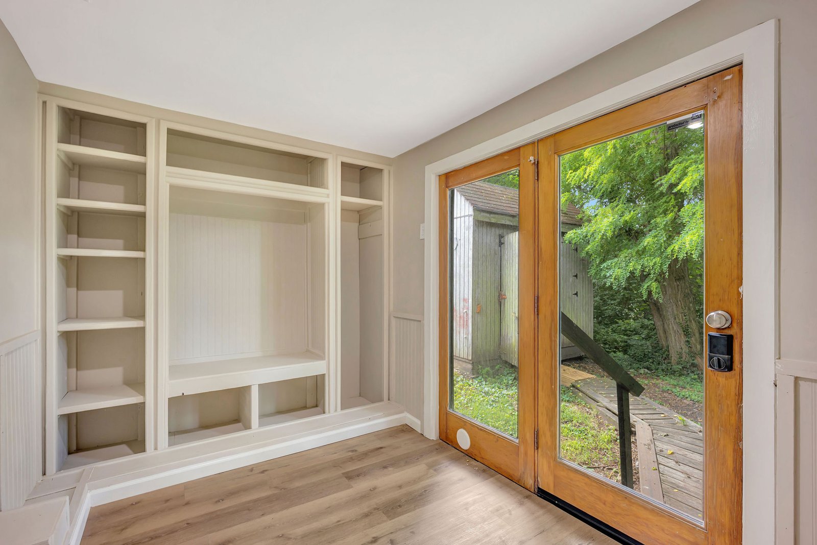 Built-in shelving beside glass doors overlooking a green backyard