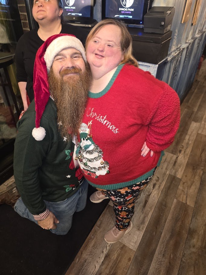 Two people posing together in holiday outfits