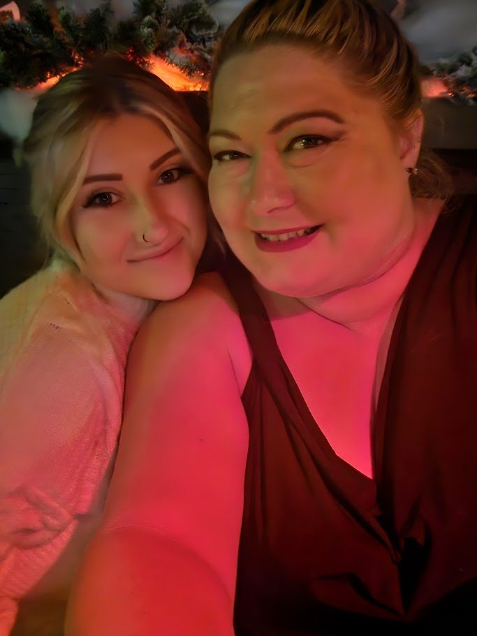 Two women smiling together at a holiday gathering