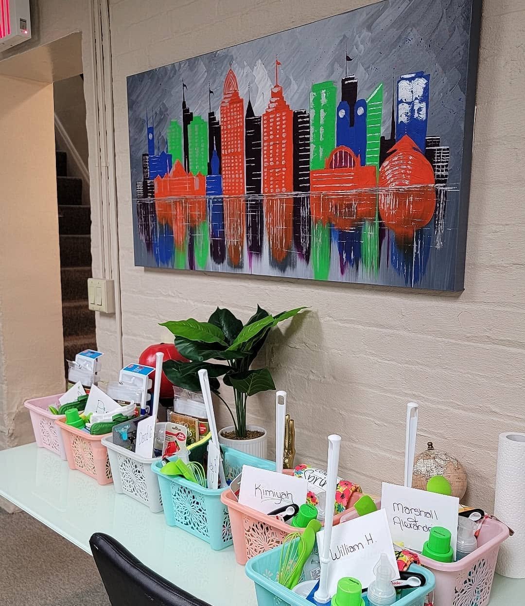 Colorful gift baskets arranged beneath Cincinnati artwork