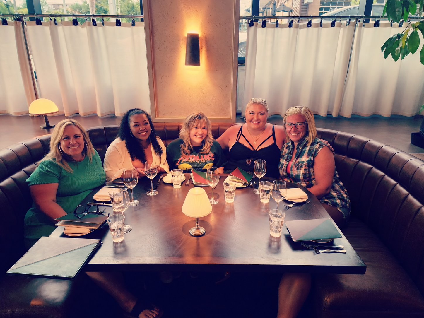 Five women gathered around a restaurant table