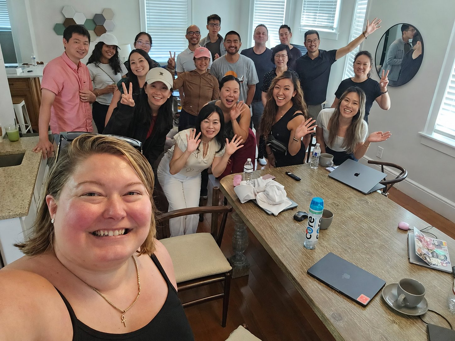 A large group smiling together in an indoor selfie