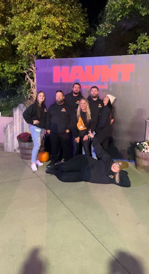 A group posing together outside a nighttime event