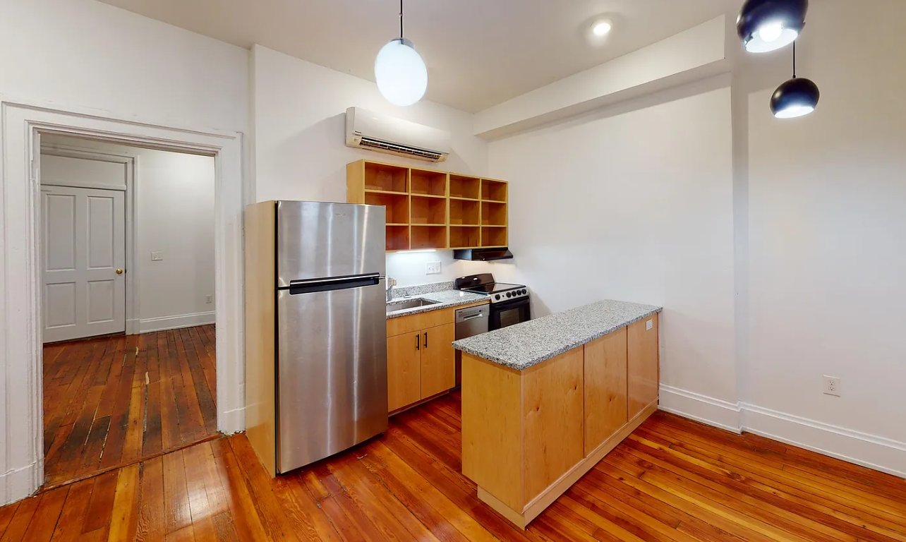 Kitchen with a granite island, wood cabinetry, and stainless steel appliances