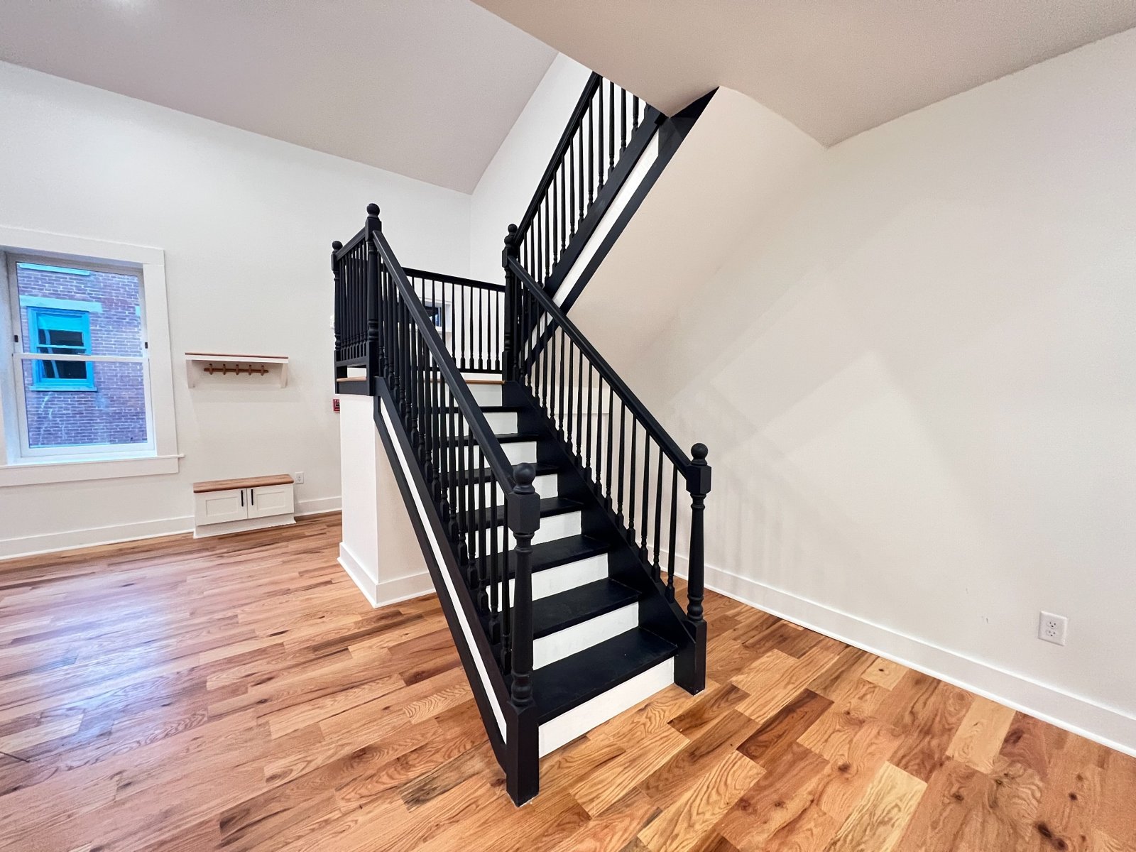 Black staircase railing and hardwood floors in an open loft